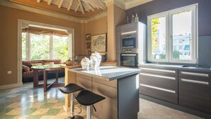 A modern kitchen with a central island, built-in oven, and a large window. - Villa Castro (Granada)