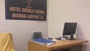 Eine Rezeption im Hotel Double Crown am Mumbai Airport T2, mit einem Computer, Tastatur, Maus und einer blauen Ordner.