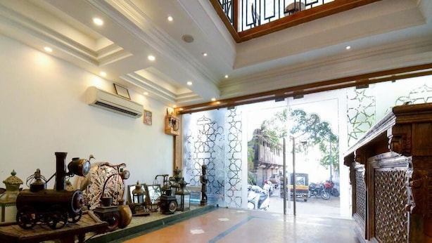 A lobby with a traditional design, featuring a patterned floor, a wooden bench, and a decorative wall with a star pattern. - The Umed (Jodhpur)
