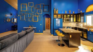 Eine moderne Küche mit blauen Wänden, einem grauen Sofa und einer Bar.