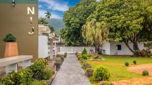 A pathway leading to a building with a sign reading "NJI". - Chez Nij Ryokan Onsen (Chiang Mai)