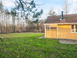 A single-story house with a tiled roof, a chimney, and a fenced yard.