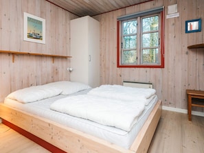 A room with a wooden bed, a window with a red frame, and a wall-mounted shelf. - 4 Star Holiday Home in Oksbol (Oksbol)