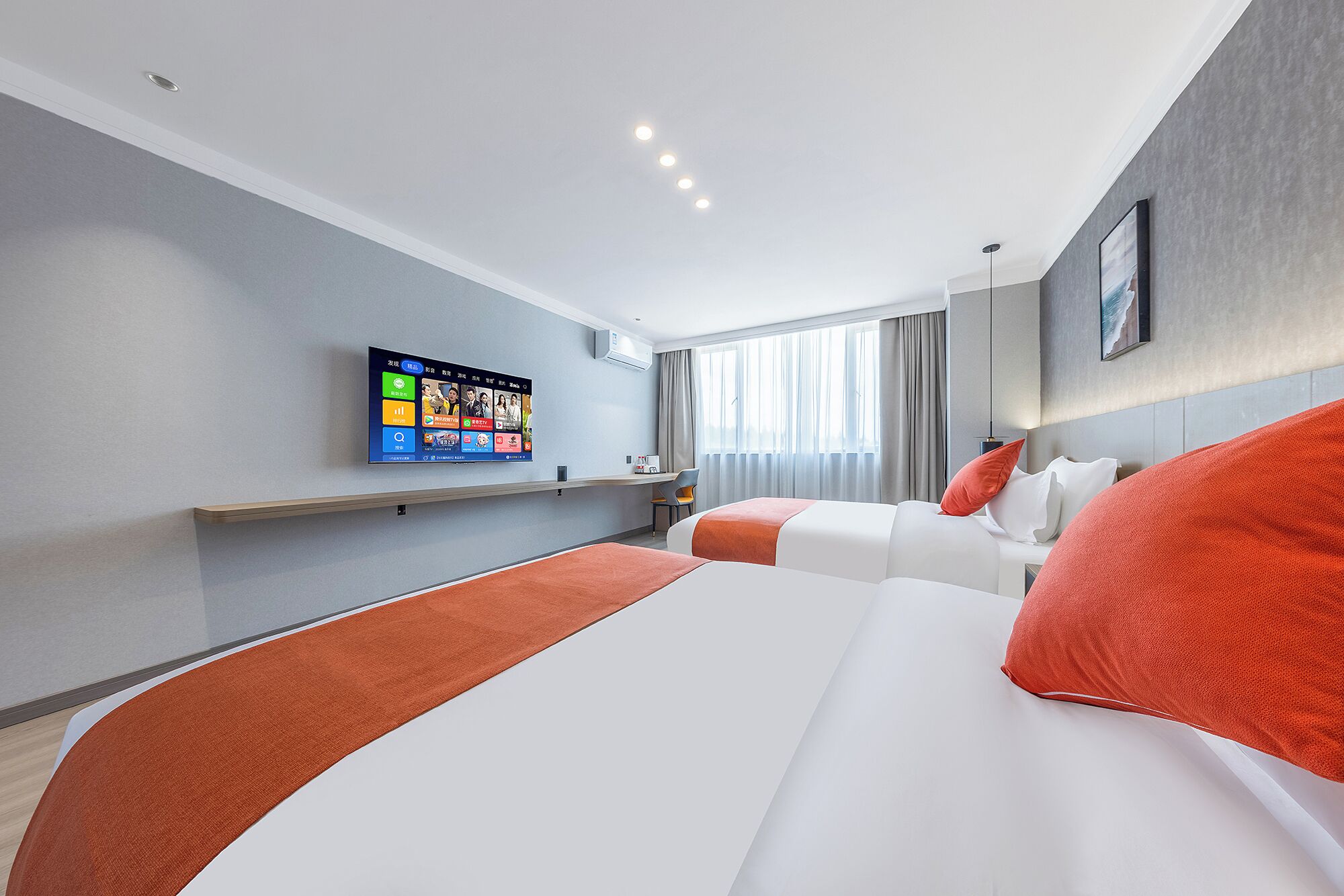 Ein modernes Hotelzimmer mit einem großen Bett, einem Schreibtisch mit Flachbildfernseher und einem Fenster mit Vorhängen.
