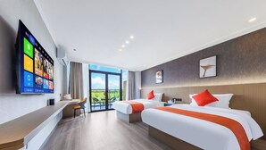 A hotel room with two beds, a desk with a chair, a TV mounted on the wall, and a balcony with a view. - Yi Jia Hotel (Kunming)