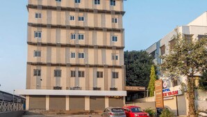 A multi-story building with a flat roof, several windows, and a sign for a hotel and restaurant. - Palette Hotel Pune, Midc Chinchwad (Pune)