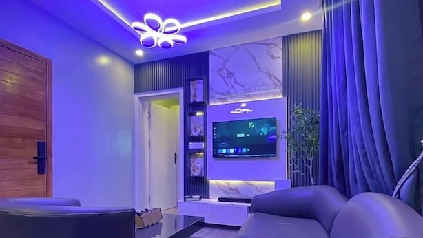A modern living room with a sofa, a coffee table, and a television.