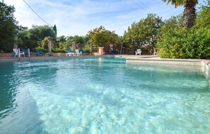 Ein klarer Pool mit Liegestühlen und einer Pergola.