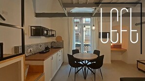 Et moderne køkken med spiseplads, med et rundt bord og sorte stole.