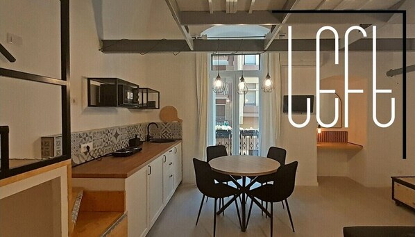 A modern kitchen with a dining area, featuring a round table and black chairs. - DIMORA "RIGHT&LEFT" Double accommodation, center of Bari, ideal for 2 families (Bari)
