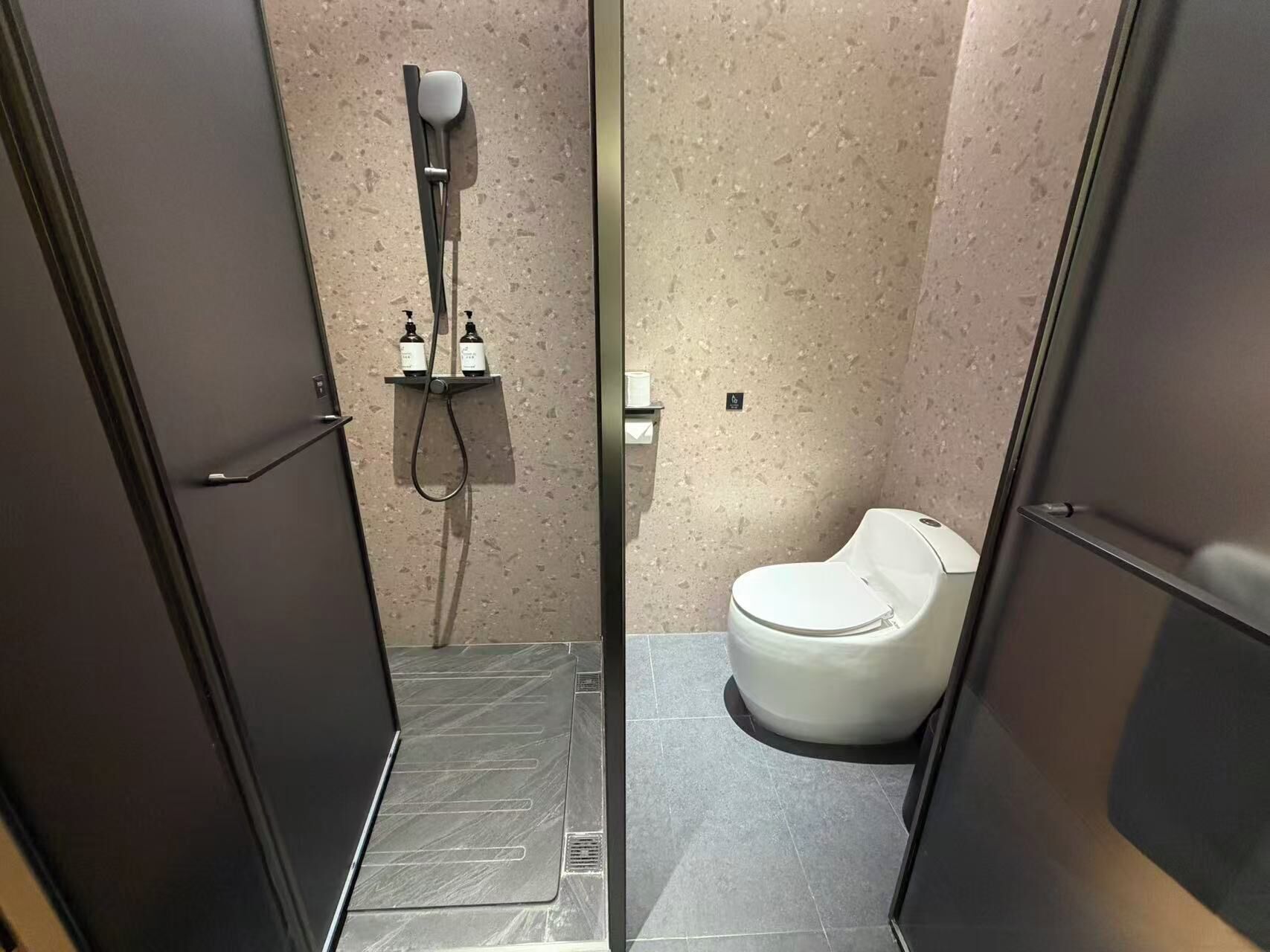 Ein modernes Badezimmer mit Dusche, Toilette und einer Glasabtrennung.