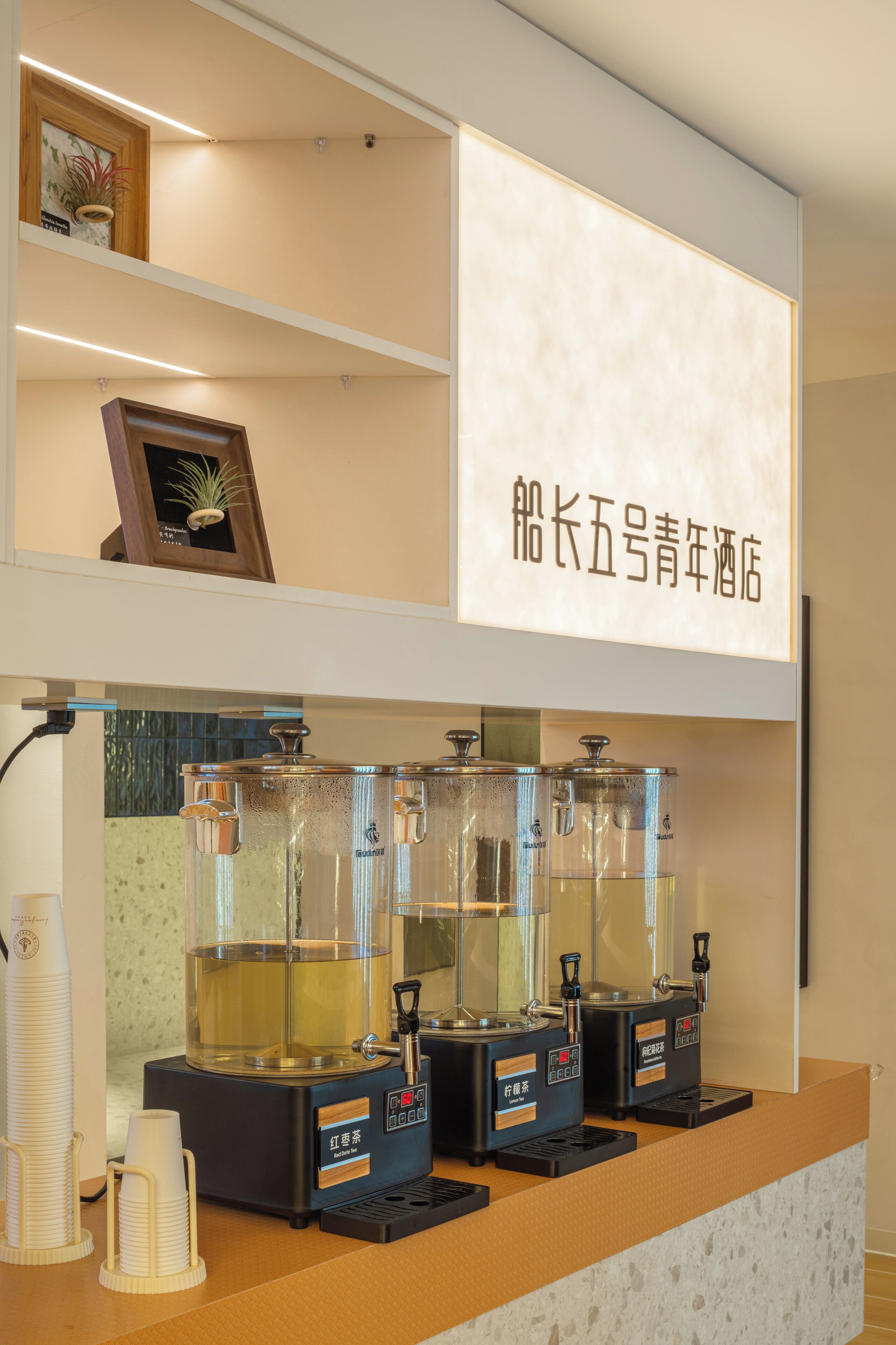 A coffee station with multiple brewing machines and disposable cups.