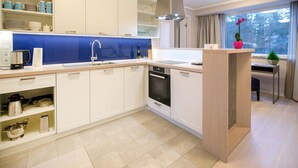 A modern kitchen with white cabinets, a blue backsplash, and a built-in dishwasher.