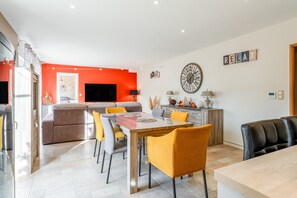 A modern living space with a dining area, kitchen, and seating. - Villa 'Vacances' with Private Pool, Wi-Fi and Air Conditioning (Orange)