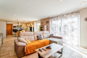 Ein modernes Wohnzimmer mit einer Couch, einem Couchtisch und einer Küche im Hintergrund.