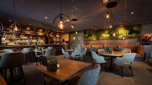 A restaurant with a bar area, multiple seating arrangements, and hanging pendant lights. - Peaceful Stay Near Trails (Veldhoven)