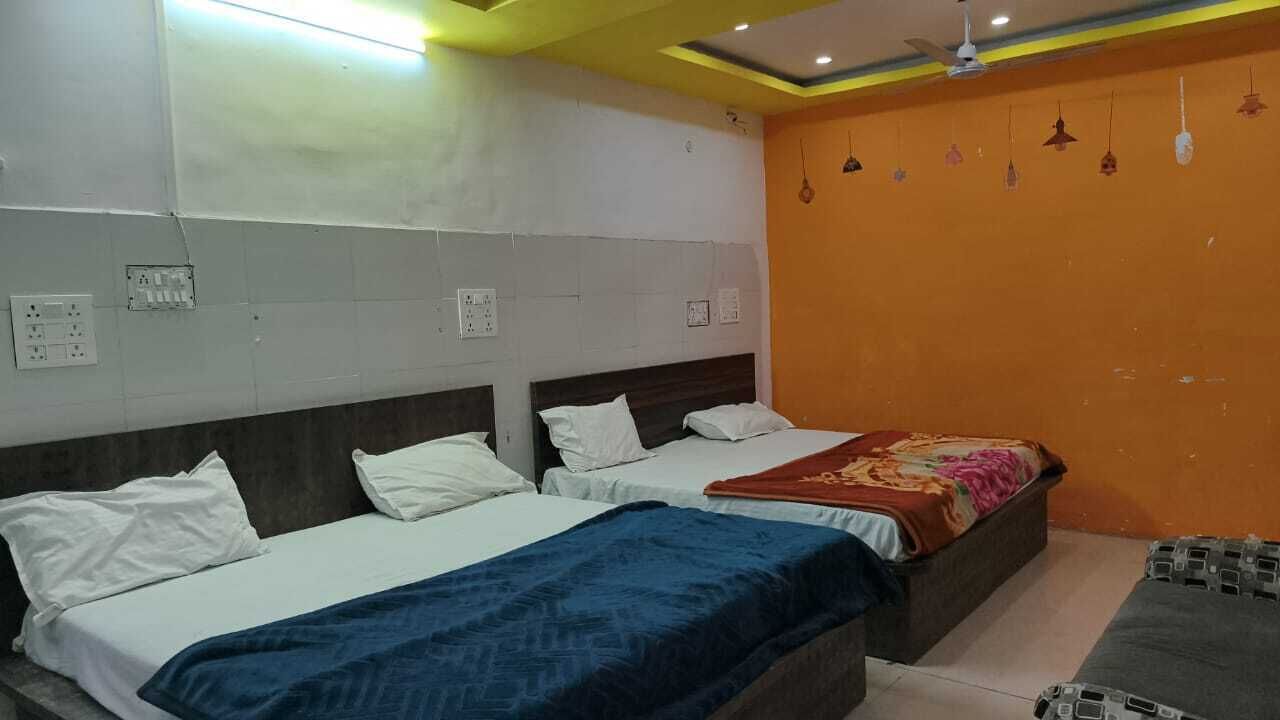 Ein Hotelzimmer mit zwei Betten, einem Deckenventilator und einer Wand mit hängenden Lampen.