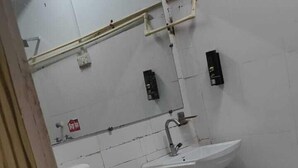 Une petite salle de bain simple, équipée d’un WC, d’un lavabo et d’un porte-serviettes.