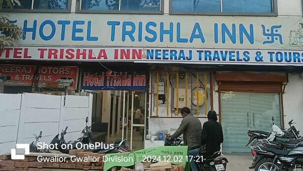Un immeuble sur lequel on peut voir des enseignes indiquant « Hôtel Trishla Inn » et « Neeraj Travels & Tours ».
