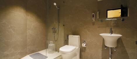 A modern bathroom with a glass-enclosed shower, a toilet, and a sink.