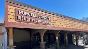A building with a sign reading "PURCELL CONDOS 1051 Gerry Sorensen Way".