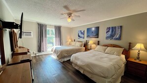 A hotel room with two beds, a ceiling fan, a TV, and artwork on the walls. - Ski, Bike, Golf, Repeat (Kimberley)
