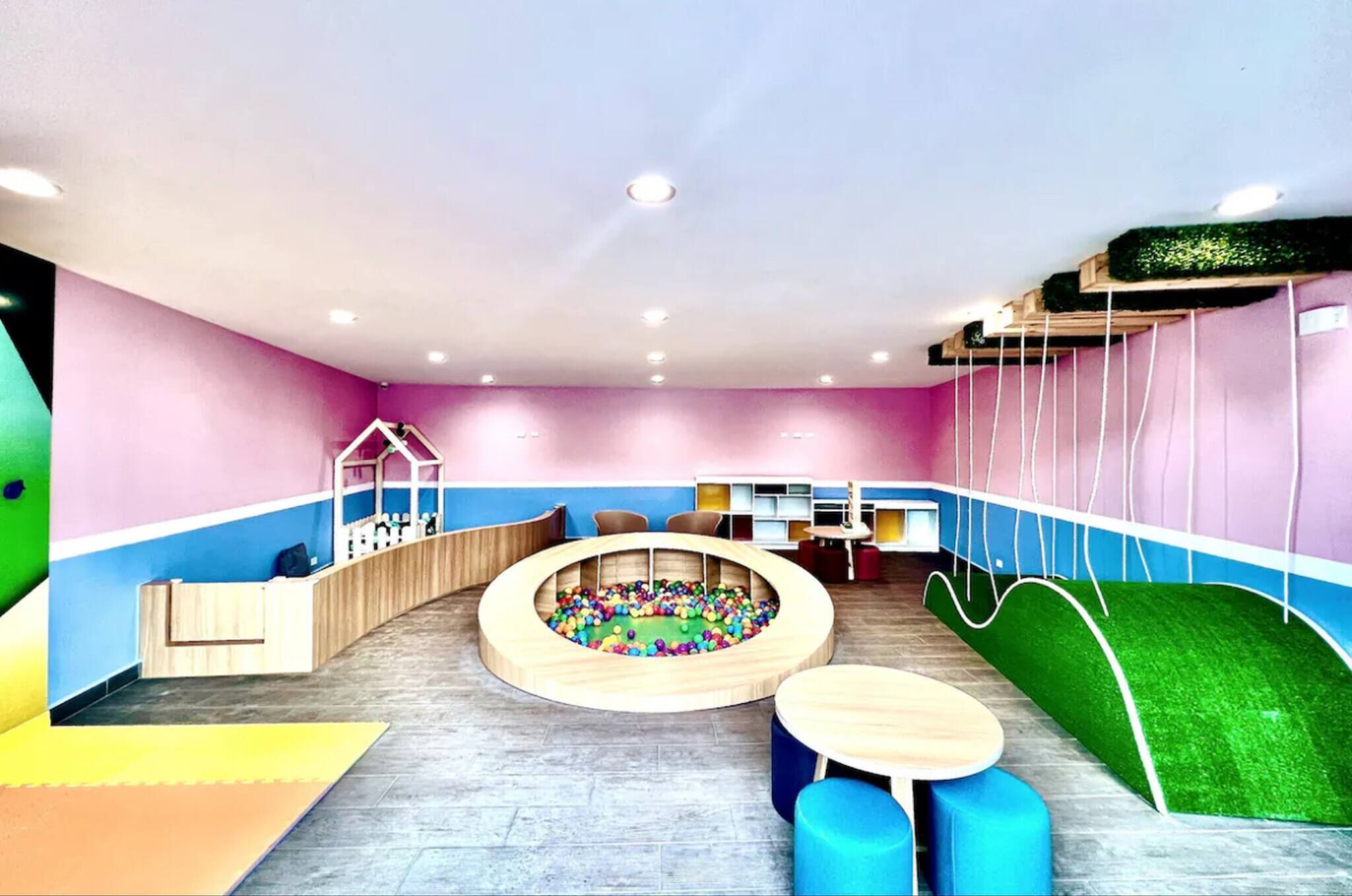 A children's play area with a ball pit, seating, and a slide.