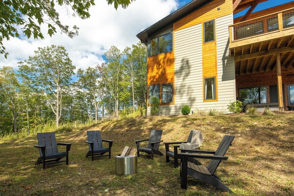 Ein modernes Haus mit einer Terrasse, umgeben von Bäumen.