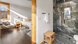 Ein modernes Schlafzimmer mit Bett, Nachttisch und einem Sessel.