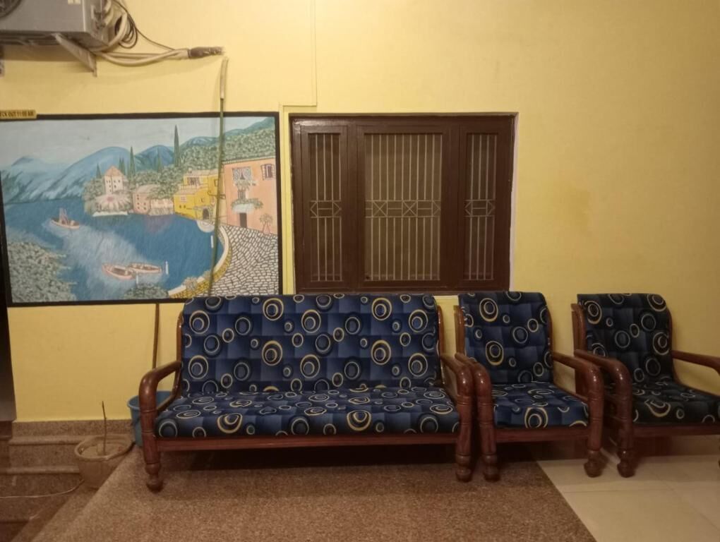 Un salón con un conjunto de sofá, un cuadro y una ventana con rejas decorativas.