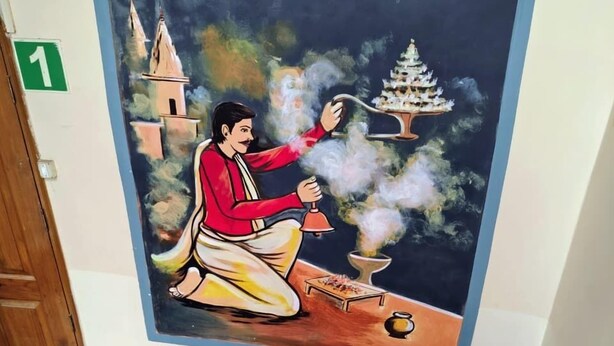 A mural of a person performing a ritual with incense and a bell, a temple in the background, and a staircase leading up. - the Gangotri inn (Varanasi)