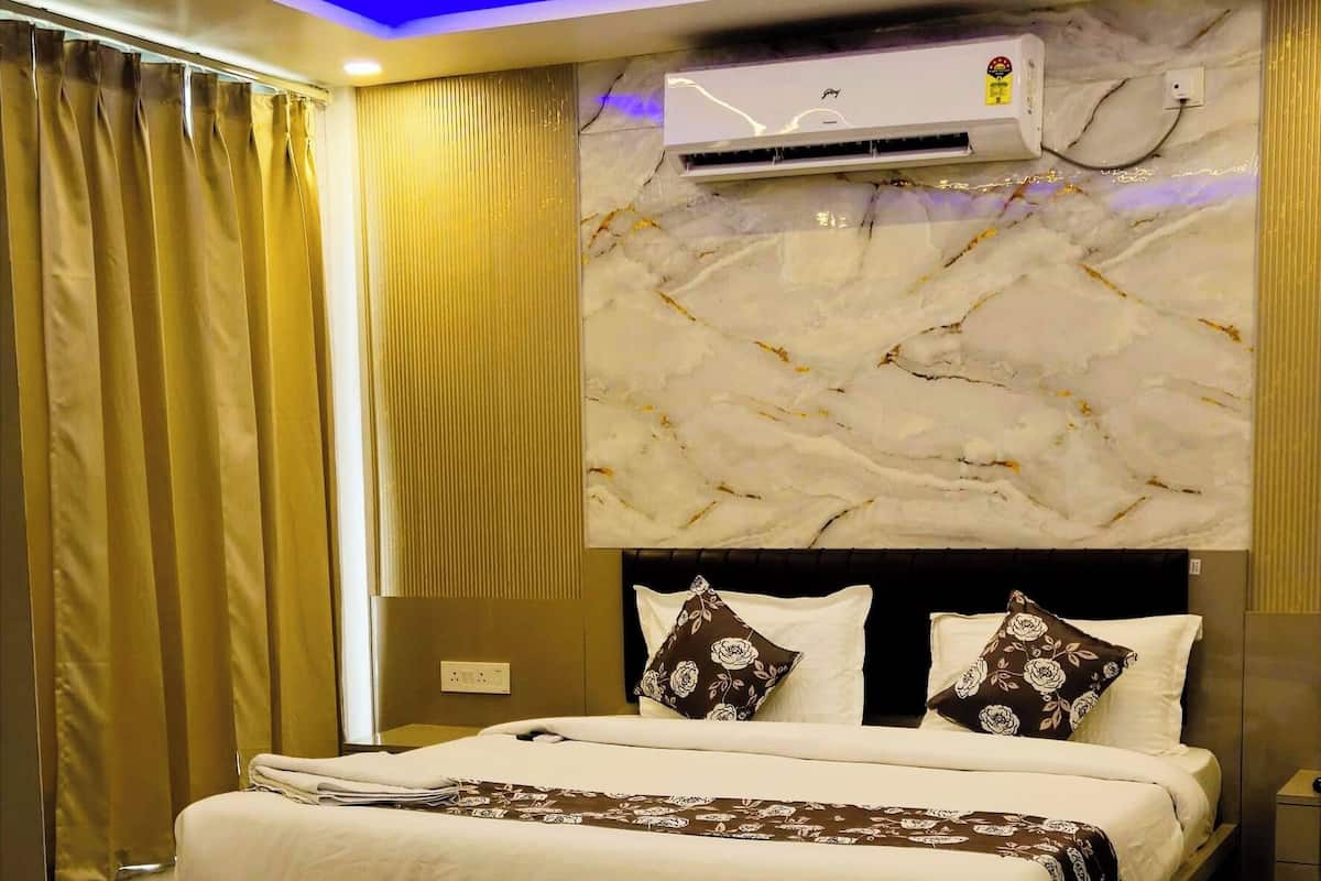 A modern bedroom with a bed, ceiling fan, air conditioning unit, and marble flooring.