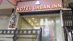 The exterior of Hotel Urban Inn with a prominent neon sign, a glass entrance, and a metal gate. - Hotel Urban Inn (Prayagraj)