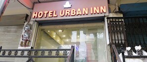 The exterior of Hotel Urban Inn with a prominent neon sign, a glass entrance, and a metal gate. - Hotel Urban Inn (Prayagraj)