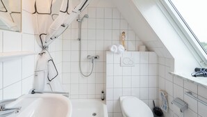Ein modernes Badezimmer mit Badewanne, Toilette und Dusche.