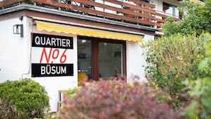 A building with a sign reading "QUARTIER N°6 BÜSUM".