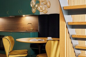 Une cuisine moderne avec des armoires de couleur turquoise, un plan de travail en bois et une chaise noire.