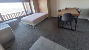 A compact room with a bed, a dining table with chairs, and a view of the outdoors. - Cosy studio for 5 near ski lift, HAMEAU C13 (Les Collons (Vex))