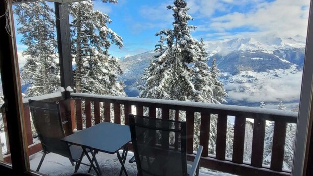 A balcony with a table and chairs, overlooking a snowy mountain landscape with trees. - Cosy studio for 5 near ski lift, HAMEAU C13 (Les Collons (Vex))