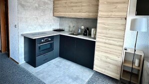 A modern kitchen with a built-in oven, a sink, and wooden cabinets. - Cosy studio for 5 near ski lift, HAMEAU C13 (Les Collons (Vex))