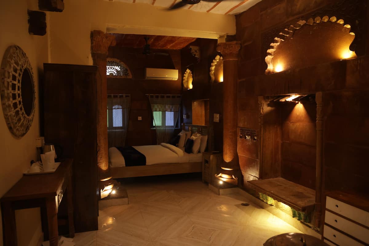 A cozy room with a bed, wooden furniture, and a fireplace.