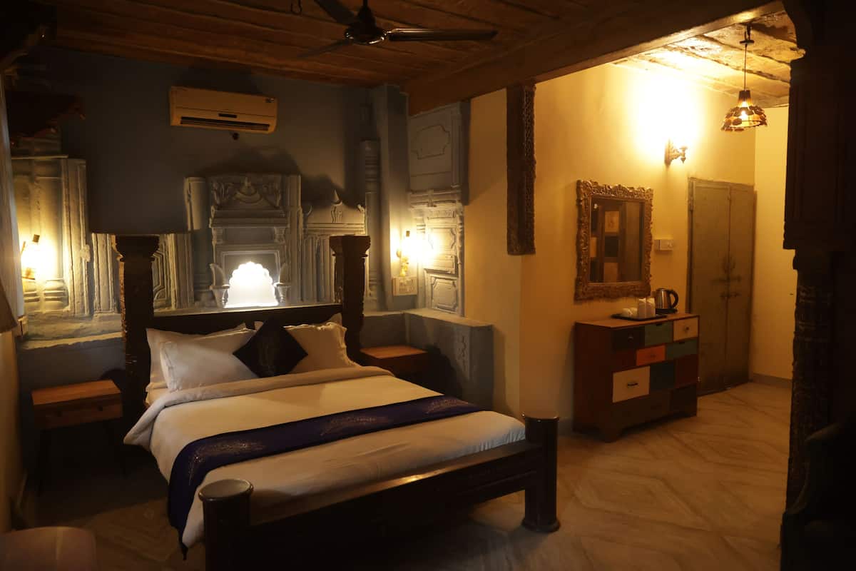 A bedroom with a wooden bed, a nightstand, a dresser, and a mirror.