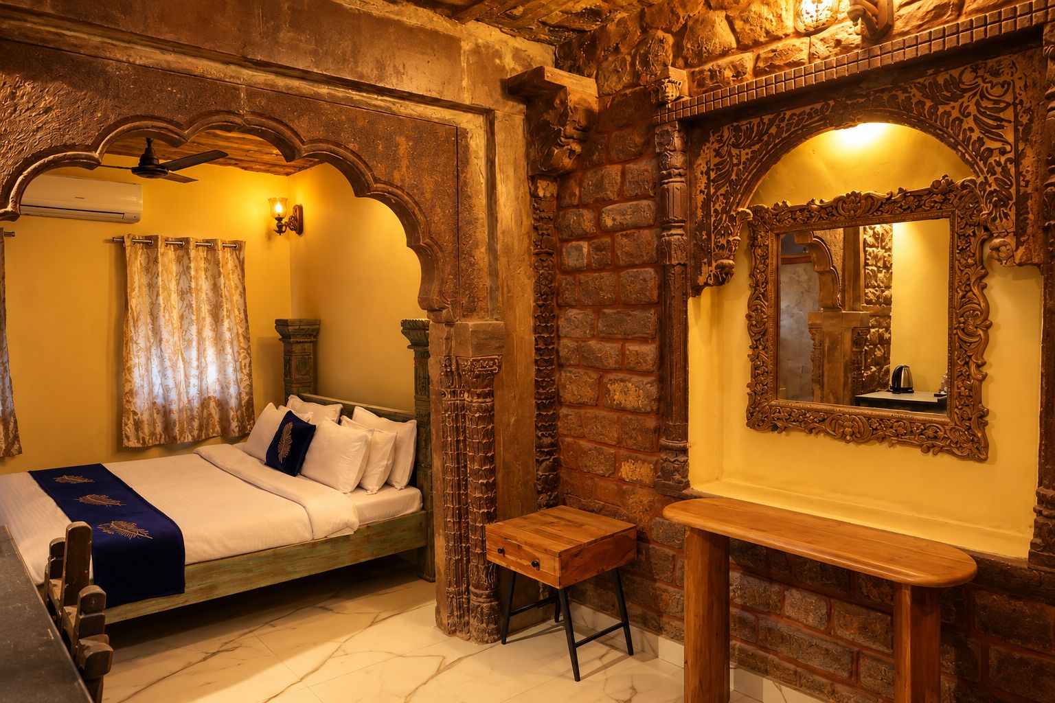 Una habitación con cama, un banco de madera, un espejo y paredes de piedra.