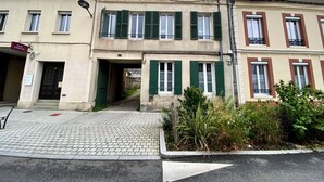Une rangée de maisons de ville avec des volets verts, une entrée pavée et une enseigne indiquant « Église évangélique ».