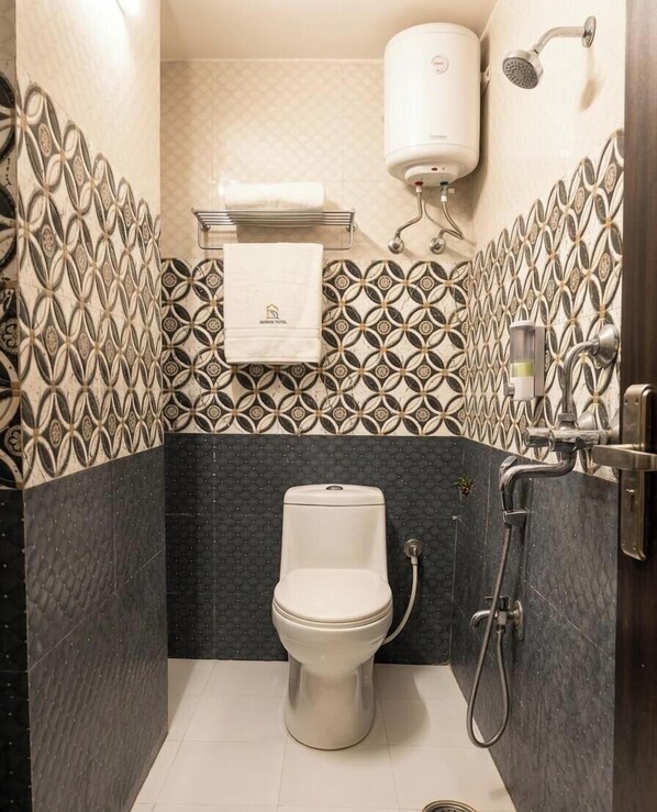 A bathroom with a toilet, a shower, and a towel rack. - Virasat Vistar Gateway (Lucknow)