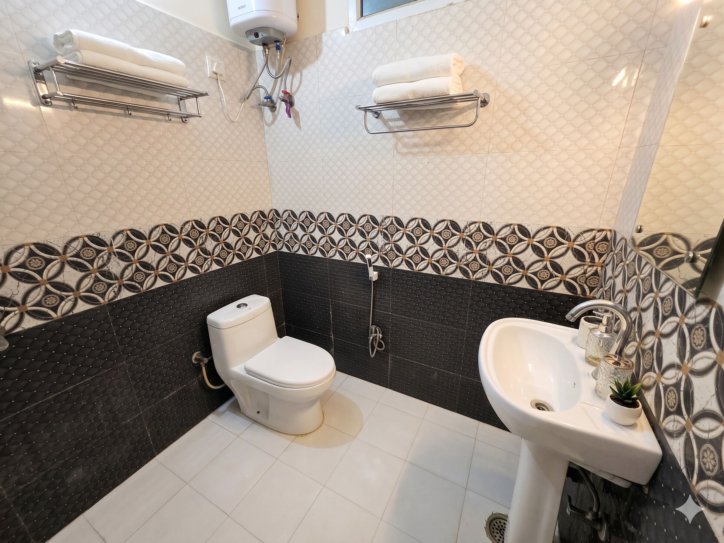 A bathroom with a toilet, sink, towel racks, and a shower.