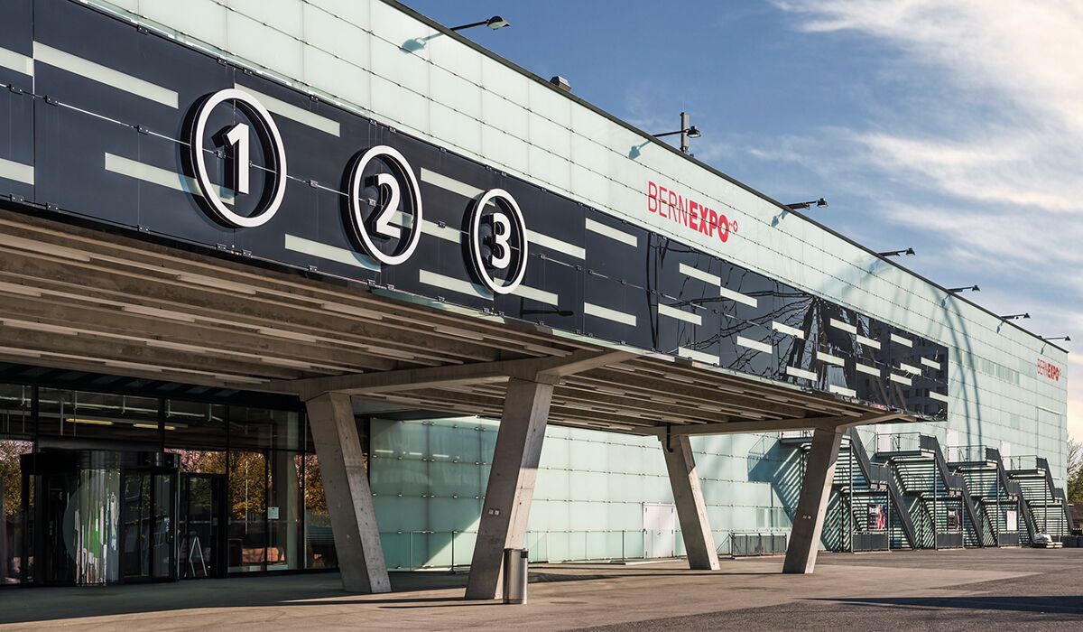 A modern building with three numbered sections and a glass facade.