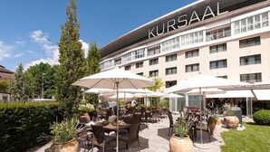 Area esterna con tavoli e ombrelloni all'hotel Kursaal.