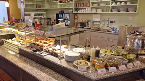Un'area buffet con diverse proposte gastronomiche e un angolo bar self-service.