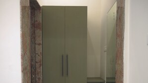 Une pièce avec une armoire, une petite étagère et un tapis sur le sol.